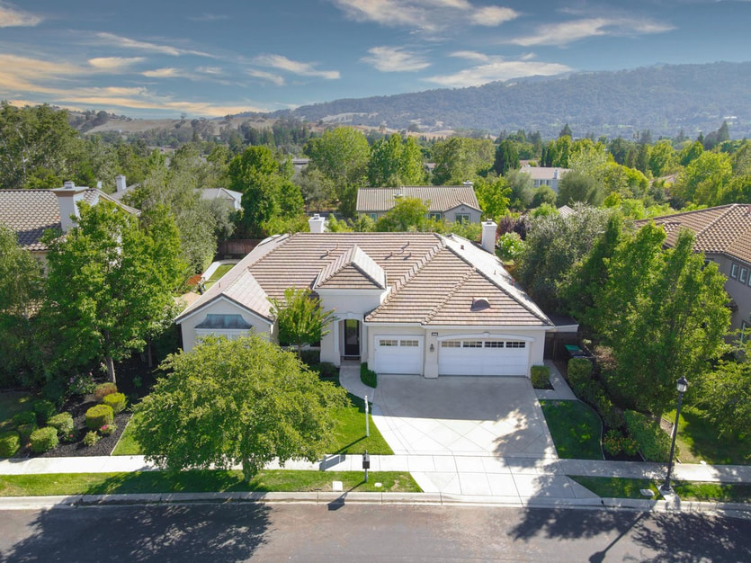 Aerial drone photo of modern home with dual garages and lots of trees in a Walnut Creek neighborhood